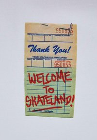 Žuta papirnata potvrda s crvenim rukopisom "DOBRODOŠLI U SKATELAND!" i plavim ispisanim elementima, s metalnom spajalom na vrhu.