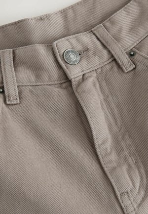 Beige Baumwollhosen mit einem silbernen Metallknopf und einer Steppnahtverzierung am Bund und am Reißverschluss. Strukturstoff mit glattem Finish.