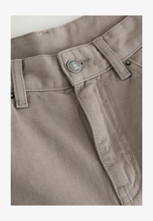 Beige cotton trousers featuring a silver metal button and topstitch detailing on the waistband and fly. Textured fabric with a smooth finish.