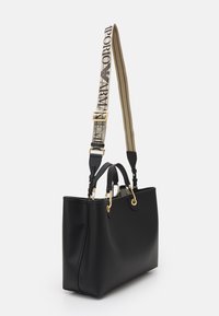 Sac à main en cuir noir avec quincaillerie dorée, deux poignées supérieures et une bandoulière réglable rayée avec logo. Texture lisse.