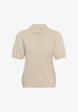 Polo de manga corta color crema con patrón de puntos texturizados, tres botones delanteros y cuello clásico.