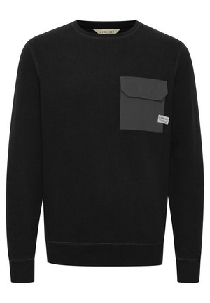 Black sweatshirt made of textured fabric, featuring a grey pocket on the left chest, round neckline, and ribbed cuffs and hem.