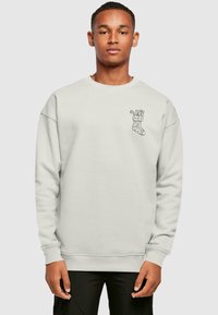 Lys grå sweatshirt med rund halsudskæring, der har et sort julefudsæksgrafik på venstre bryst og rib strikkede manchetter og talje.