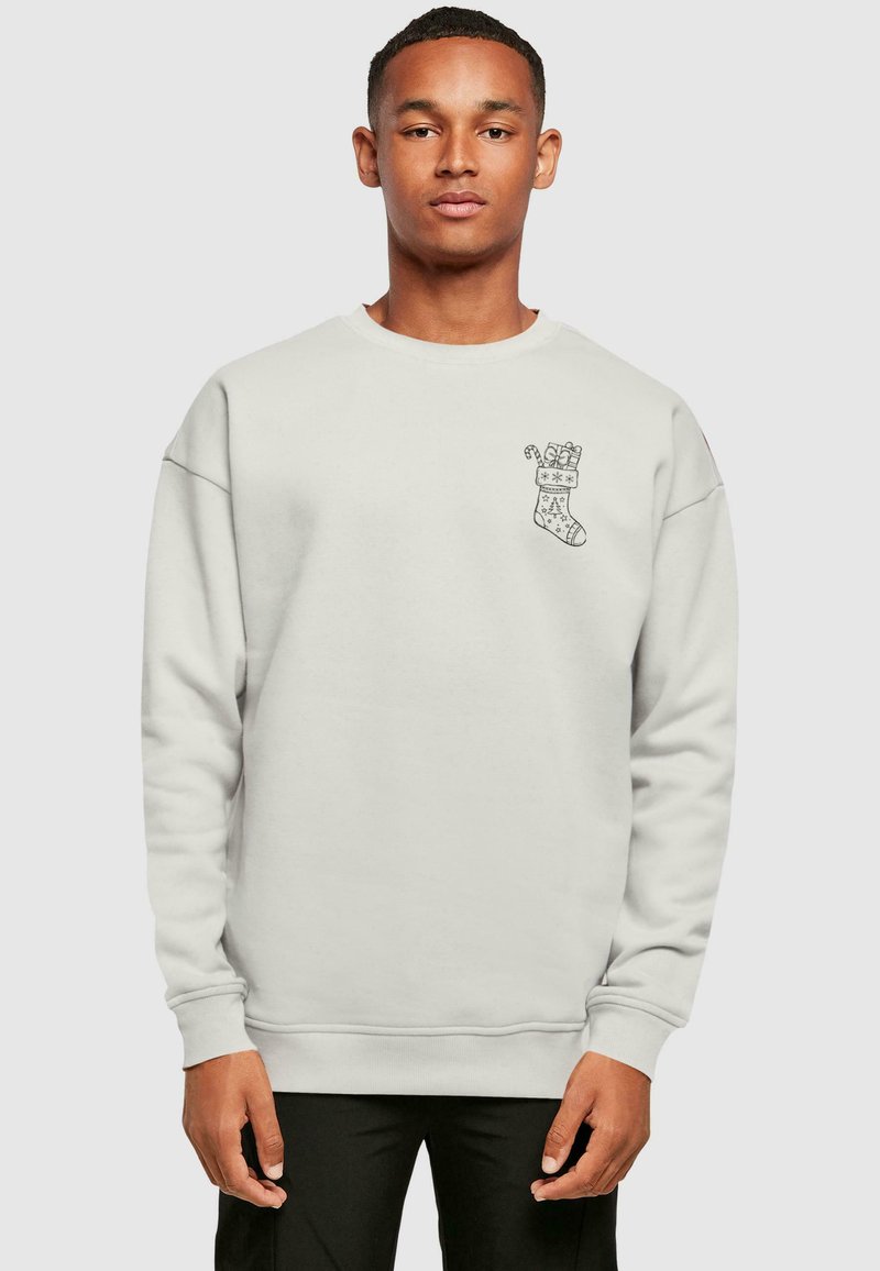 Lys grå sweatshirt med rund halsudskæring, der har et sort julefudsæksgrafik på venstre bryst og rib strikkede manchetter og talje.