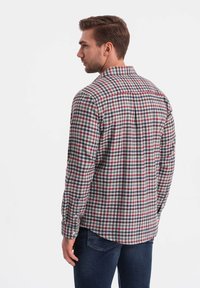 Camicia a quadri da uomo in rosso, blu navy e bianco. Presenta un colletto button-down e maniche lunghe, realizzata in tessuto leggero.