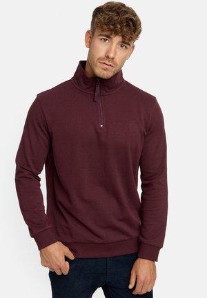 Bordeaux rits sweatshirt met hoge hals, ribbelboorden en -zoom, met een subtiele logo op de borst, gemaakt van zachte stof.