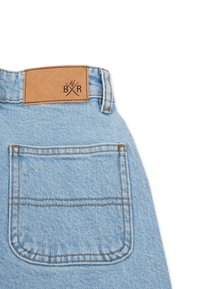 Světle modré džíny z denimu se čtvercovou zadní kapsou a hnědou koženou etiketou s embosovaným nápisem "BXR". Viditelné stehy v kontrastní niťi.