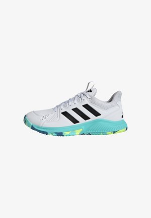 Chaussure de sport blanche avec des rayures noires, une semelle intermédiaire turquoise, une semelle multicolore, un talon en mesh et un design à lacets.