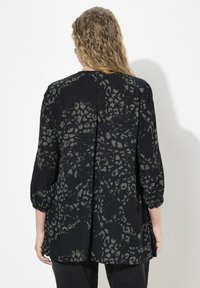 Sort bluse med grå leopardprint, trekvartlange ærmer, plisseret rygdetalje og en afslappet pasform, lavet af letvægtsstof.