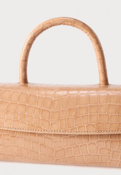 Sac à main beige avec un motif texture crocodile et une anse arrondie sur un fond clair uni.