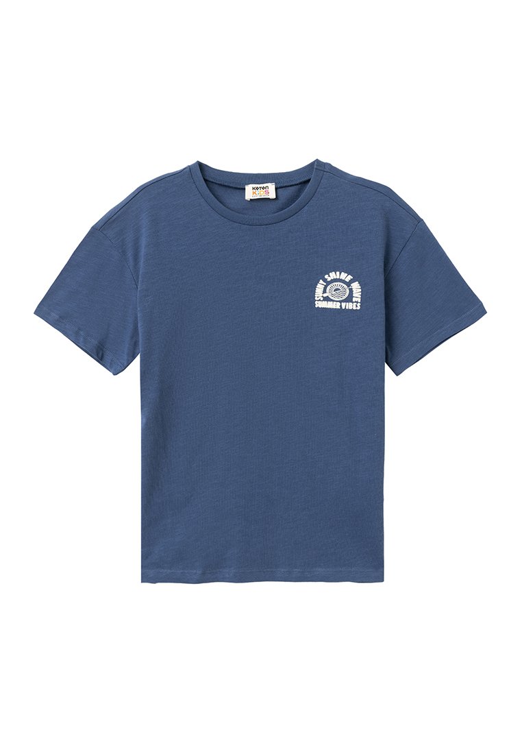 Camiseta de algodón azul con mangas cortas y cuello redondo. Presenta un diseño impreso en blanco que dice "VIBRAS DE VERANO" en el lado izquierdo del pecho.