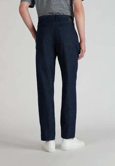 Navy denim broek met een rechte pasvorm, voorzien van subtiele achterzakken, een gladde textuur en een hoge tailleband, gecombineerd met witte sneakers.