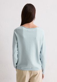 Hellblaues Sweater mit weicher Textur, langen Ärmeln und einem leicht weiten Bootsausschnitt. Die Rückseite hat ein sauberes, einfaches Design.