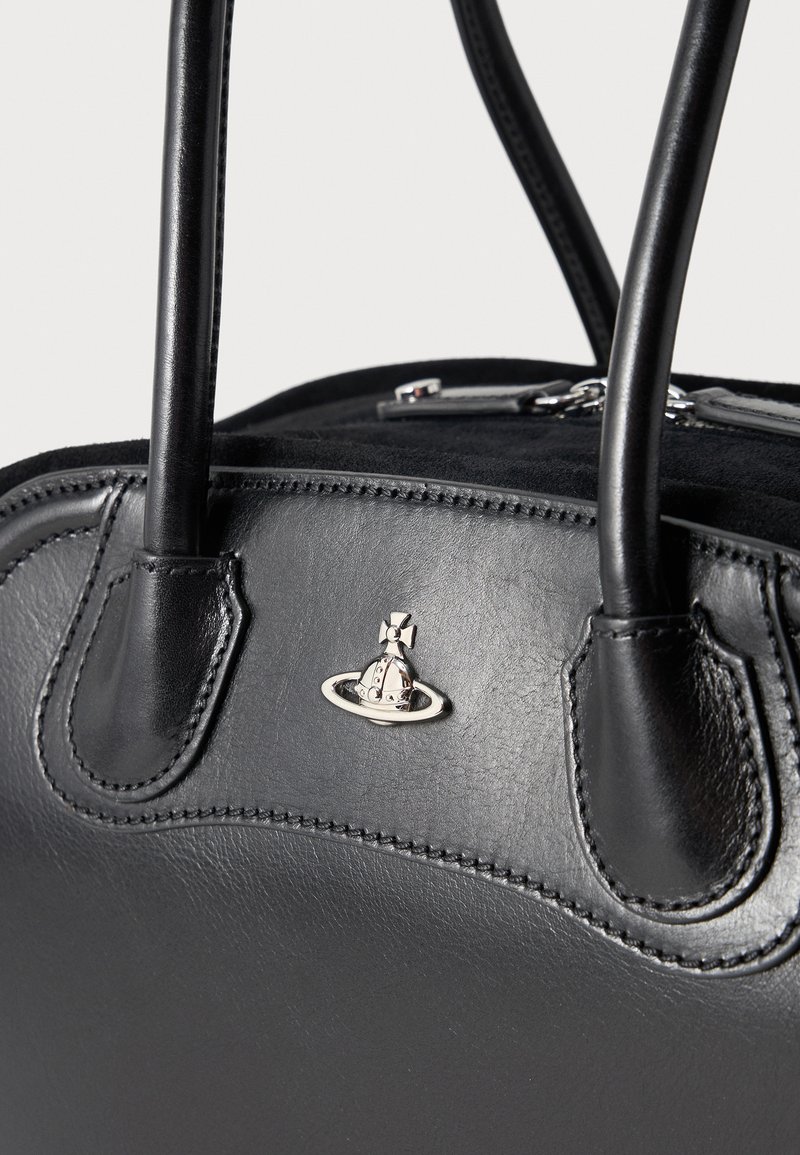 Black leather handbag with stitched handles and a silver orb logo centered on the front panel against a plain background.