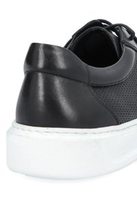 Czarne skórzane sneakersy z perforowaną fakturą, białą gumową podeszwą i zaokrąglonym obcasem. Posiadają sznurowadła i gładkie wykończenie cholewki.