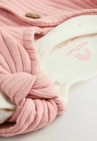 Nauhatut vaaleanpunainen ribbikangas, jossa on sileä kerma-alaosa, puunappitieto ja pehmeä rakenne, erinomainen vauvanvaatteisiin.