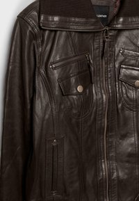 Ciemnobrązowa skórzana kurtka z wieloma kieszeniami na zamek i na guziki, zamknięciem na zamek z przodu oraz detalami z prążkowanym kołnierzem.
