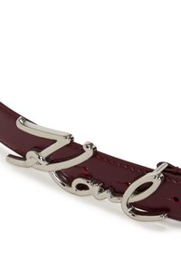 Curea din piele burgundy, cu accesorii din argint lucios și un logo stilizat. Textura netedă și elementele de design curbat îmbunătățesc aspectul său.