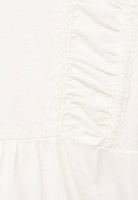 Tessuto bianco con dettaglio a strisce verticali increspate e testurizzate, che mette in mostra morbide pieghe e un materiale a maglia fine.