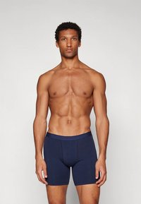 Mörkblå bomullsboxershorts med en mjuk textur och elastisk midjeresår, med minimala sömmar och en funktionell framficka.