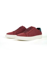 Bordeaux sneakers met een gestructureerde bovenkant, witte rubberen zool en een blauwe accent aan de achterkant. Veters in bijpassende bordeauxkleur.