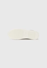 Sneaker sole, rubber material, textured tread pattern, cream color, flat design, with branding details near the heel area.