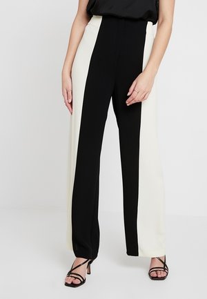 Hoge taille wijde pijpen broek met een zwart-wit kleurblok ontwerp, zachte stof en een getailleerde pasvorm. Aangevuld met minimale hardware.