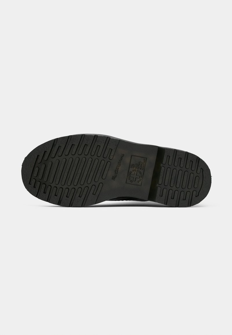Suela de zapato de goma negra con dibujos en relieve y logo y texto grabados sobre un fondo blanco liso.