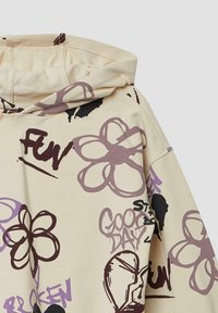 Felpa con cappuccio in cotone beige, caratterizzata da stampe grafiche di fiori e testo in viola e nero, con una vestibilità ampia e colletto a coste.