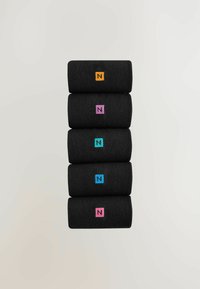 En uppsättning av fem svarta tygsnurror staplade vertikalt, var och en med en broderad "N"-logo i olika färger: orange, rosa, blå, teal och lila.
