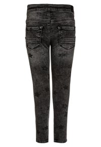 Leggings de mezclilla negra con un patrón de estrellas, cinco bolsillos y un corte ajustado, con una textura ligeramente desgastada para un aspecto usado.