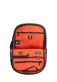 Zaino nero con un interno arancione, caratterizzato da un motivo topografico, numerose tasche con zip e etichette di marca in colori a contrasto.
