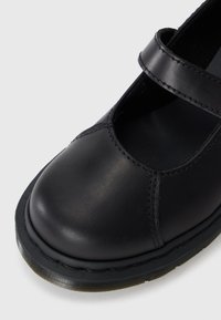 Zwarte leren Mary Jane-schoen met een ronde neus, gestikte details en een strap over de wreef. De buitenzool is van rubber met structuur.