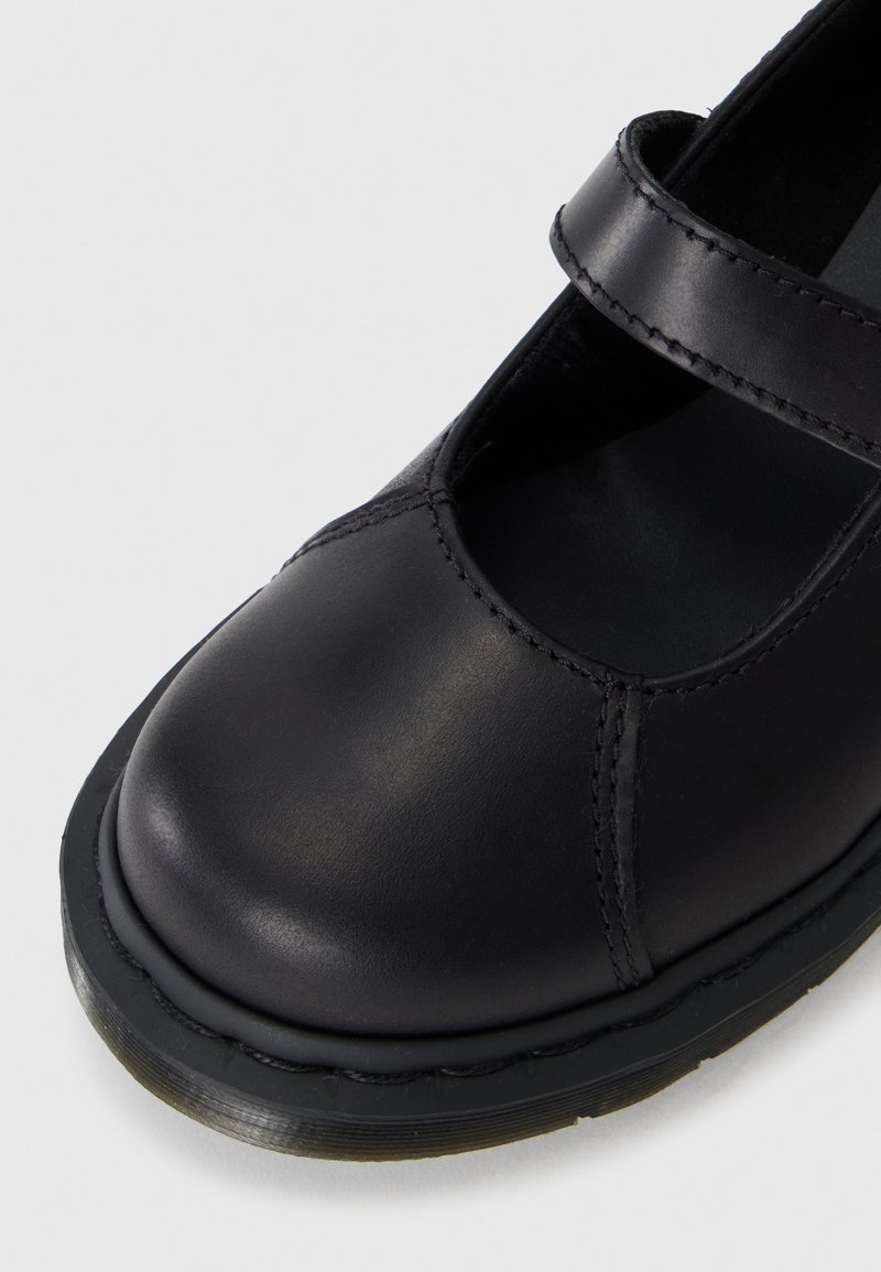 Zwarte leren Mary Jane-schoen met een ronde neus, gestikte details en een strap over de wreef. De buitenzool is van rubber met structuur.