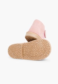 Zapatillas de ante rosa con suela de goma texturizada, que presentan una puntera redondeada y detalle de correa ajustable para un ajuste seguro.