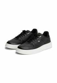 Sneaker in pelle nera con suola in gomma bianca, dotati di dettagli perforati, lacci rotondi e accenti dorati sui fori per i lacci.