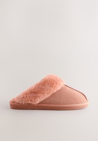 Chausson rose avec un bord duveteux et texturé, corps en tissu lisse et semelle solide. Présente des coutures apparentes et un design minimaliste.