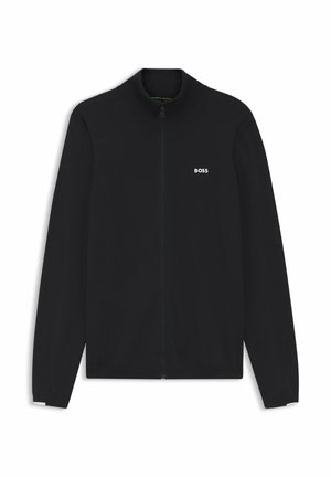 Svart zip-up jacka i mjukt tyg. Hög krage med ribbad struktur och diskret vit logotyp på vänster bröst. Figursydda ärmar.