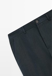 Pantalon formel noir avec passants pour ceinture, bouton à l'avant et poches latérales, présenté sur un fond blanc.
