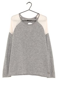 Pull gris à manches longues avec des panneaux d'épaule en voile beige clair, suspendu sur un cintre noir contre un fond blanc.