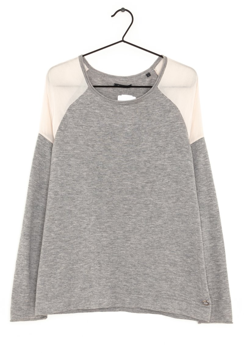 Pull gris à manches longues avec des panneaux d'épaule en voile beige clair, suspendu sur un cintre noir contre un fond blanc.