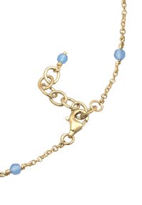 Bracelet en chaîne dorée avec des perles bleu clair, un fermoir en homard et des maillons circulaires entrelacés avec une finition polie.