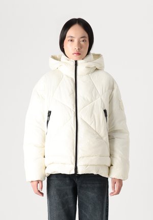 Giacca a vento bianca con cappuccio, caratterizzata da un motivo a losanghe trapuntato, zip frontale e tasche laterali con accessori in metallo nero.