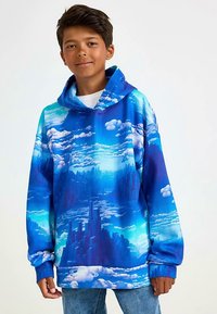 Hooded sweatshirt featuring a blue and white cloud pattern, with a soft texture and a loose fit, worn over a white shirt and denim.