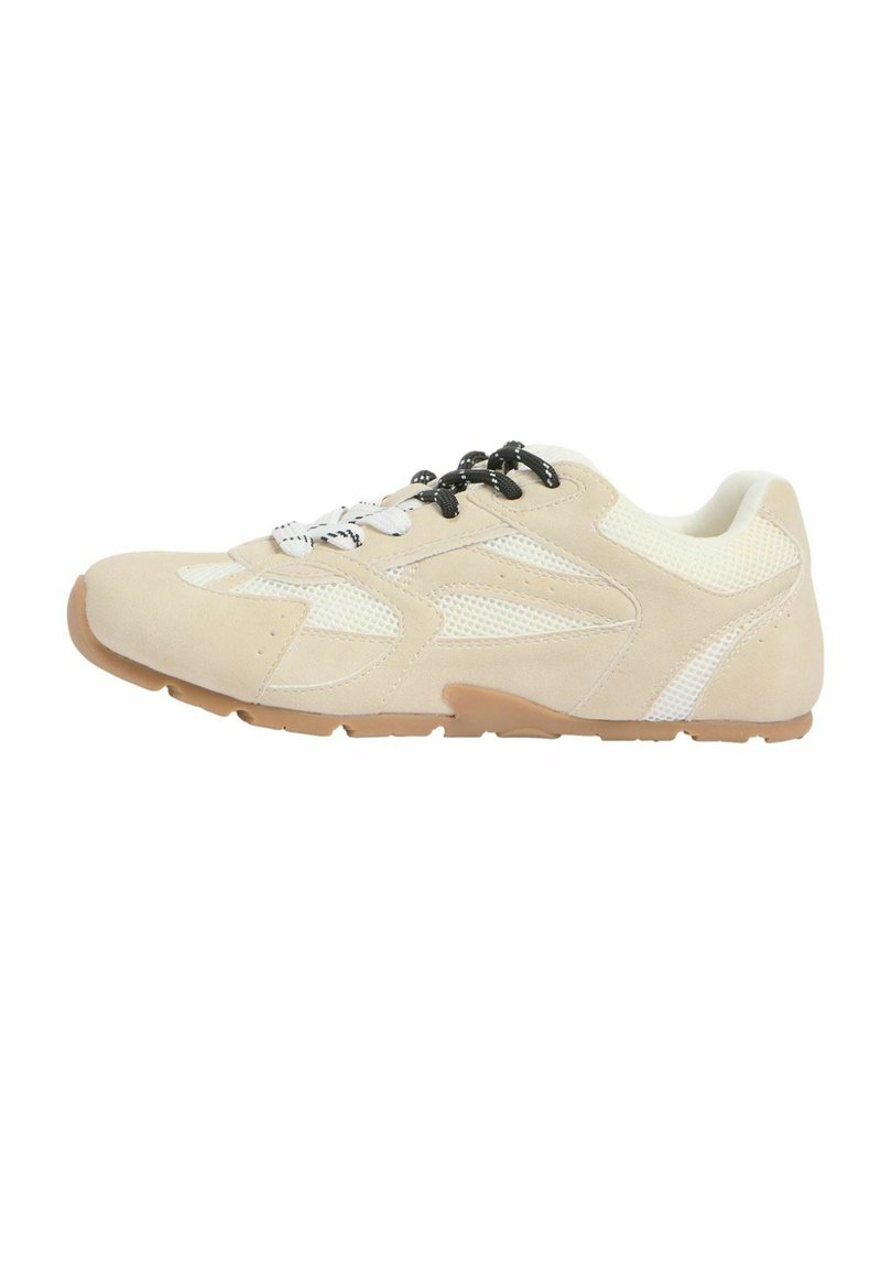 Chaussure de sport beige et blanche avec tige en matériaux mixtes, lacets contrastants noirs et blancs, et semelle en caoutchouc marron, vue de profil.