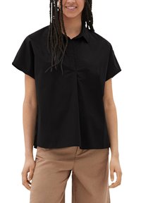 Zwarte short-sleeve shirt met een kraag en een relaxte fit. Heeft een knoopsluiting aan de voorkant en subtiele plooien bij de buste.