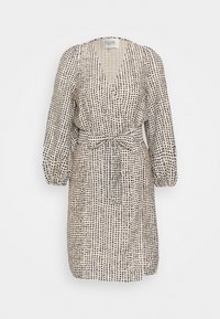 Knelång klänning i beige med svart prickmönster, har en V-ringning, långa puffärmar och en knytning i midjan för formning.