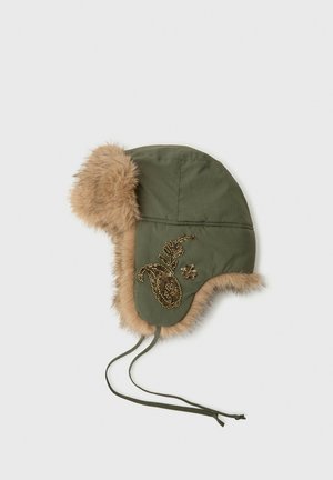 Chapeau de trappeur d'hiver vert avec bordure en fourrure et broderie avec des perles dorées sur le côté, avec des rabats d'oreilles et de longues lanières à nouer.