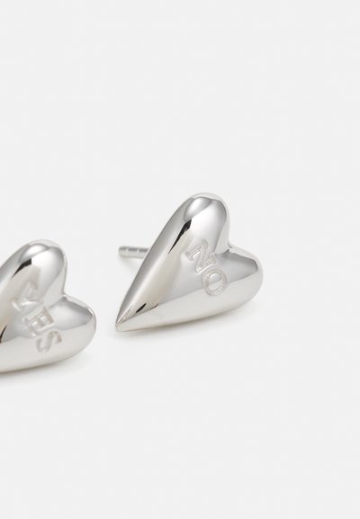 Boucles d'oreilles en argent en forme de cœur avec le texte gravé "OUI" sur l'une et "NON" sur l'autre, surface polie et attache à tige.