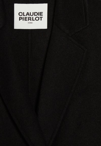 Blazer de lana negra con solapa muesca, que presenta detalles de costura y una etiqueta de marca blanca que dice "CLAUDIE PIERLOT PARIS."